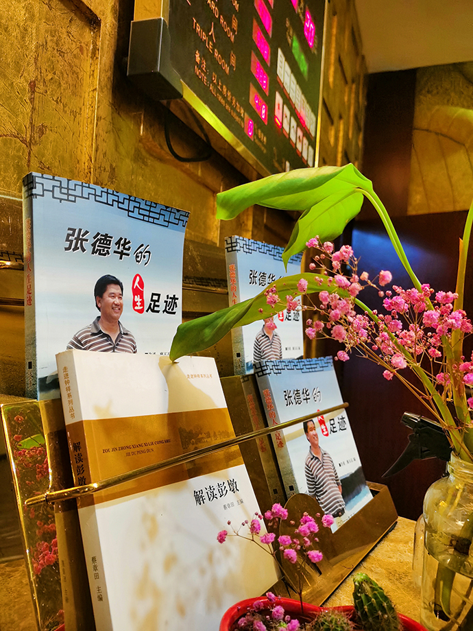 彭墩集团旗下的酒店,前台摆着宣传张德华的书。